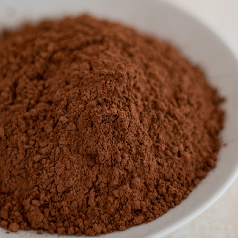 Red cocoa powder, soft and fluffy in a shallow white bowl. This is the most premium Santa Barbara Chocolate Red Baking cocoa powder.